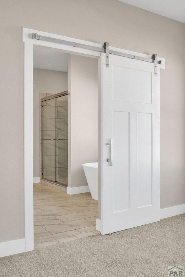 interior space with a freestanding bath, a shower stall, and baseboards