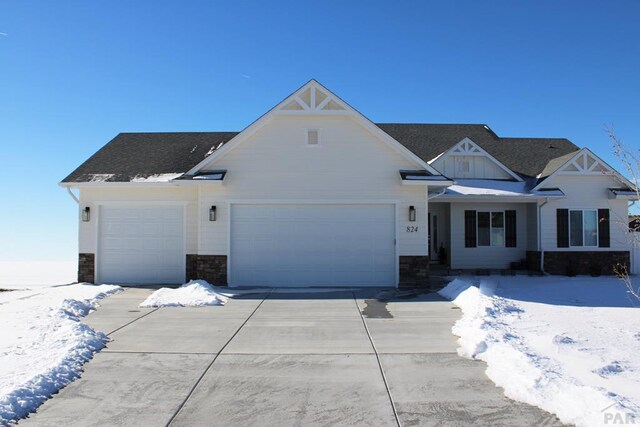 view of front of house with board and batten siding, concrete driveway, stone siding, and a garage