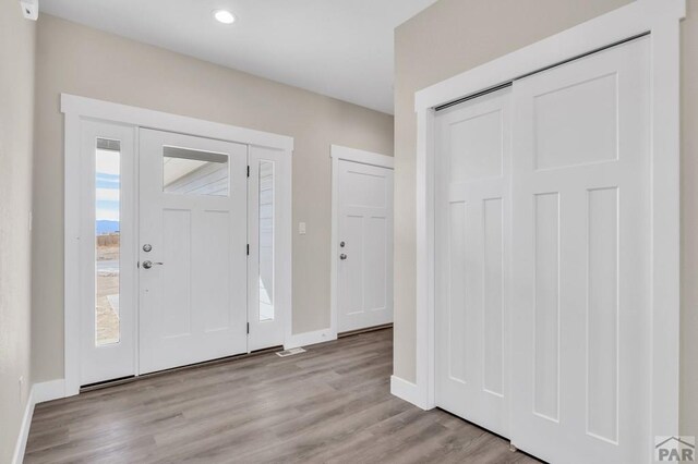 entrance foyer featuring light wood-style flooring, baseboards, and recessed lighting