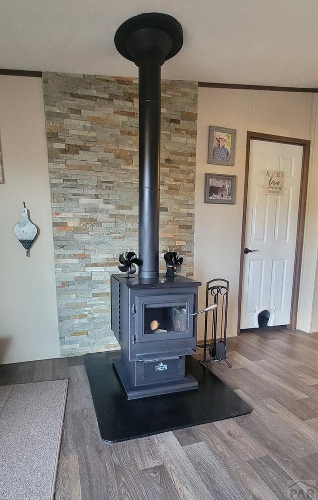 details with a wood stove and wood finished floors