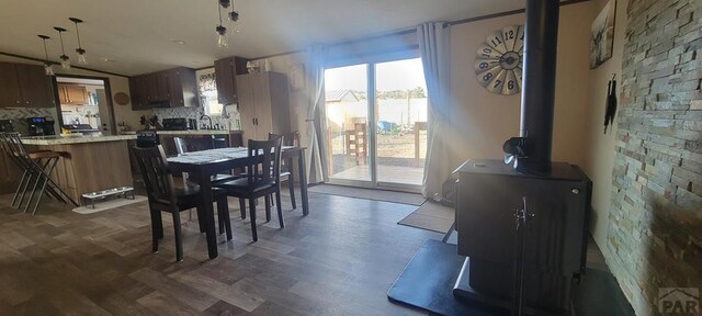 dining room with dark wood-style floors and a wood stove