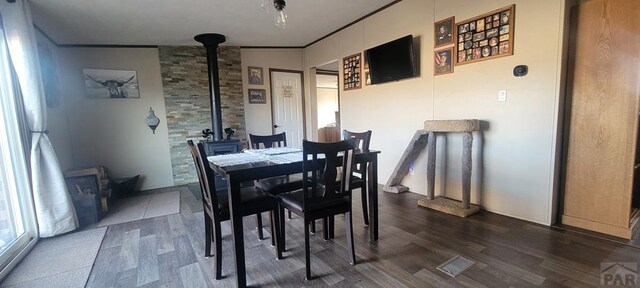 dining area featuring ornamental molding and dark wood-type flooring