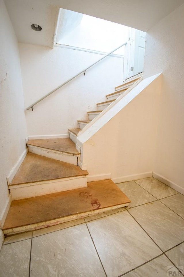 1142 Elm St, Pueblo, CO 81004 - staircase with baseboards and tile patterned floors