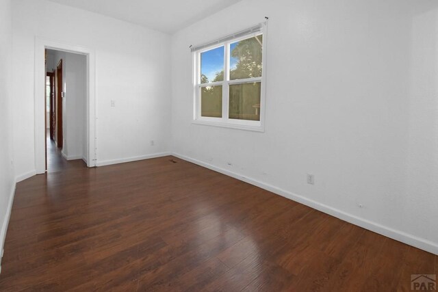 1142 Elm St, Pueblo, CO 81004 - empty room featuring baseboards and dark wood-style floors