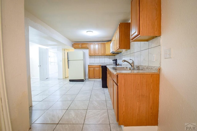 1142 Elm St, Pueblo, CO 81004 - kitchen with freestanding refrigerator, light countertops, light tile patterned floors, backsplash, and a textured wall