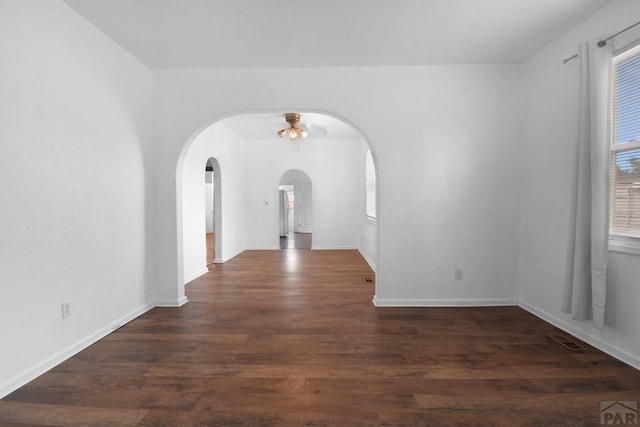 1142 Elm St, Pueblo, CO 81004 - spare room featuring arched walkways, wood finished floors, and a ceiling fan