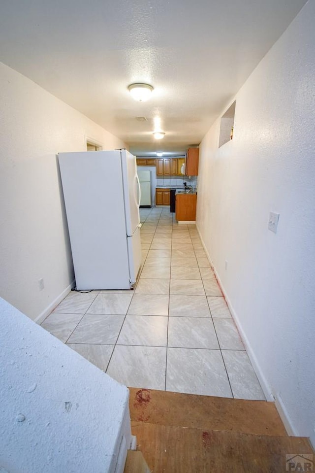 1142 Elm St, Pueblo, CO 81004 - kitchen with freestanding refrigerator and brown cabinets