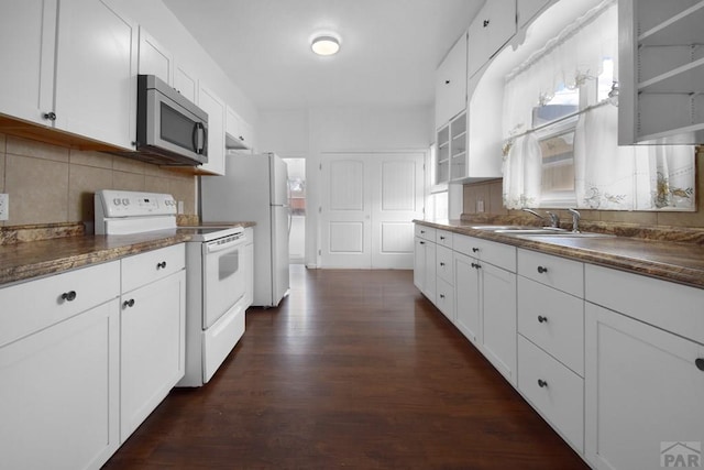 1142 Elm St, Pueblo, CO 81004 - kitchen featuring white appliances, dark wood finished floors, white cabinetry, backsplash, and dark countertops