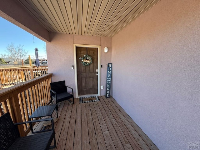 property entrance featuring a balcony and stucco siding