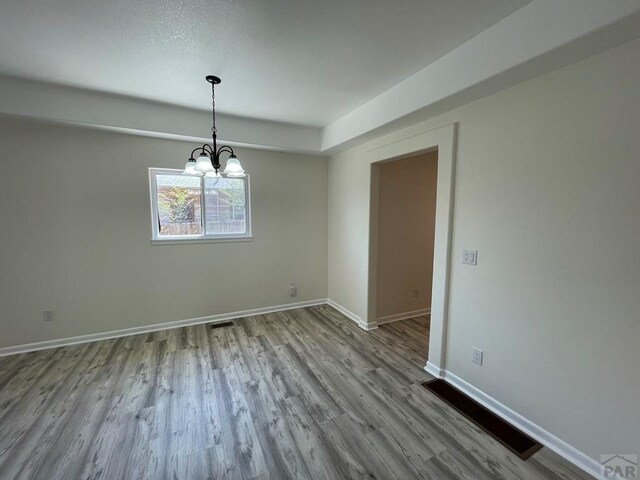 interior space with light wood-style floors, baseboards, and a notable chandelier