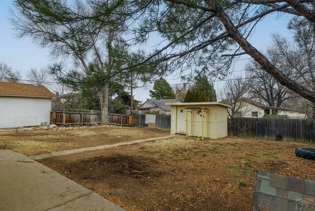 view of yard with an outbuilding, a fenced backyard, and a storage shed