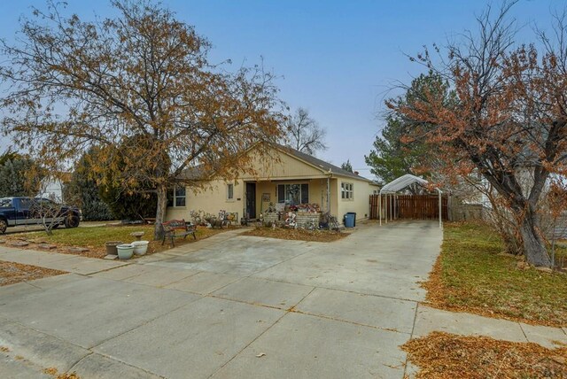 view of front of house with stucco siding, driveway, and fence