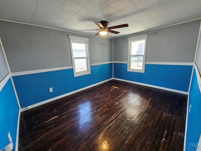 spare room with plenty of natural light, wood finished floors, and baseboards