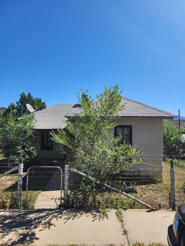 view of front facade with fence and stucco siding