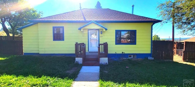 bungalow with a shingled roof and fence