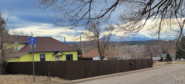 view of side of property featuring fence and a mountain view