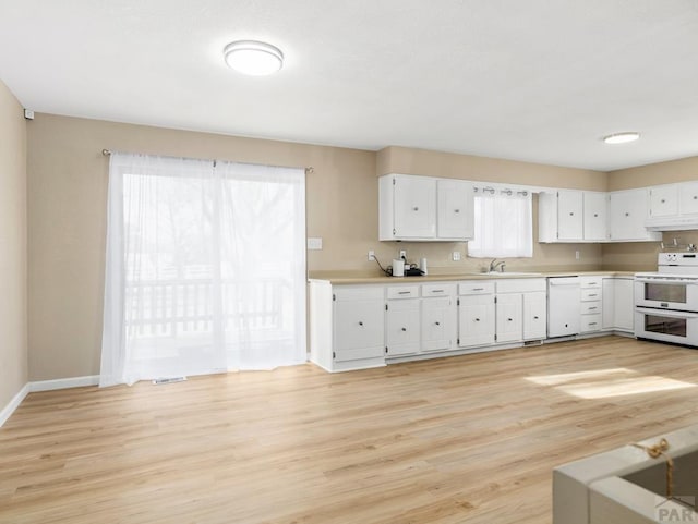 760 Crystal Ln, Pueblo, CO 81006 - kitchen with white appliances, white cabinets, a sink, light countertops, and a wealth of natural light