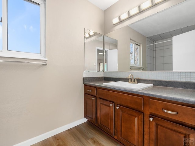 760 Crystal Ln, Pueblo, CO 81006 - bathroom featuring vanity, baseboards, backsplash, and wood finished floors