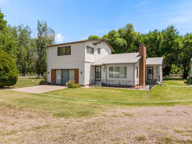 760 Crystal Ln, Pueblo, CO 81006 - view of front of home with roof with shingles, a chimney, concrete driveway, a garage, and a front lawn
