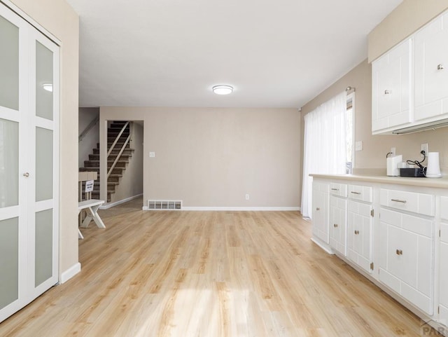 760 Crystal Ln, Pueblo, CO 81006 - kitchen featuring visible vents, white cabinets, baseboards, light countertops, and light wood-style floors