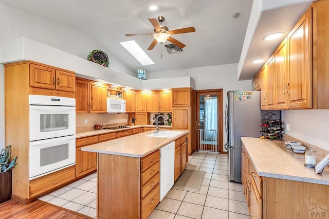 29 Portero Dr, Pueblo, CO 81005 - kitchen with white appliances, a sink, a ceiling fan, a skylight, and a kitchen island with sink