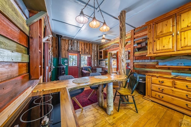 361 Crystal Peak Rd, Florissant, CO 80814 - kitchen with brown cabinets, hanging light fixtures, light wood-style floors, a wood stove, and wood counters