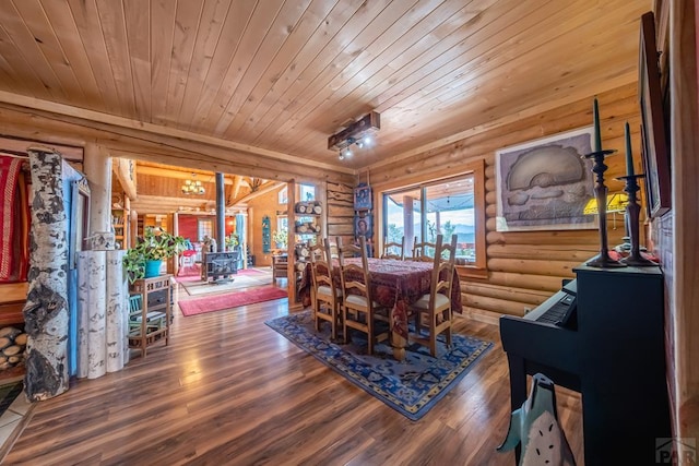 361 Crystal Peak Rd, Florissant, CO 80814 - dining space with a wood stove, wooden ceiling, rustic walls, and wood finished floors