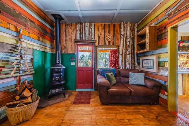 361 Crystal Peak Rd, Florissant, CO 80814 - sitting room with wood finished floors, a wood stove, and wooden walls