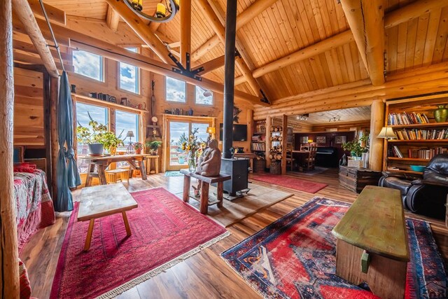 361 Crystal Peak Rd, Florissant, CO 80814 - living area with a wood stove, wooden ceiling, beam ceiling, and wood finished floors