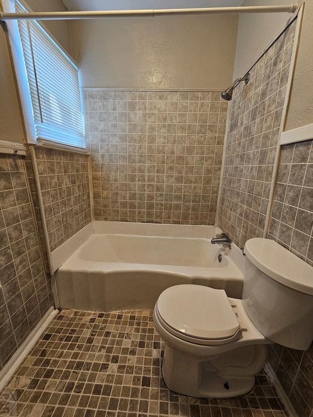 full bathroom with bathtub / shower combination, tile walls, toilet, and tile patterned floors