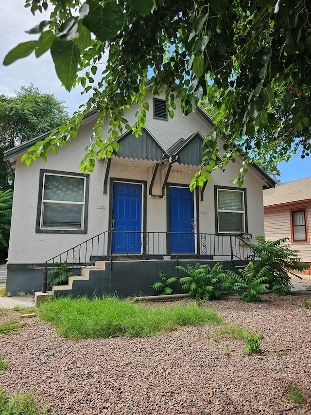 bungalow featuring stucco siding