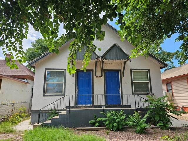 view of front of property with fence and stucco siding