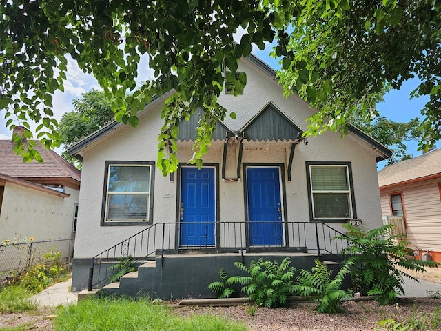 view of front of property with fence and stucco siding