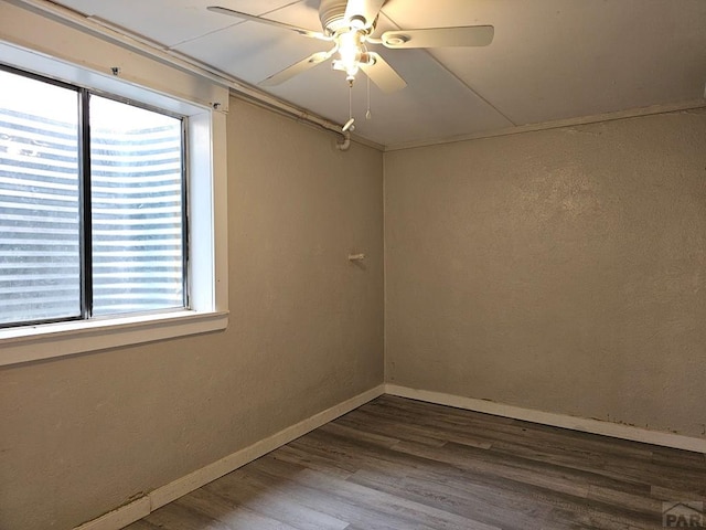 spare room with dark wood-style floors, ceiling fan, and baseboards