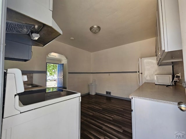 kitchen with visible vents, white cabinets, dark wood finished floors, light countertops, and exhaust hood