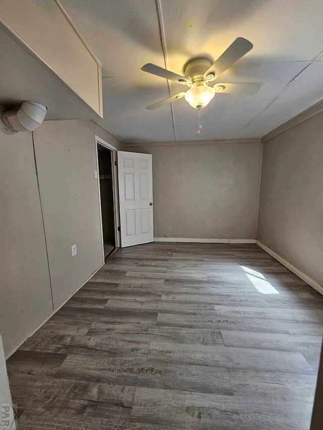 empty room with dark wood finished floors and a ceiling fan