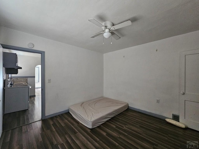 bedroom featuring dark wood-style floors, visible vents, a sink, ceiling fan, and baseboards