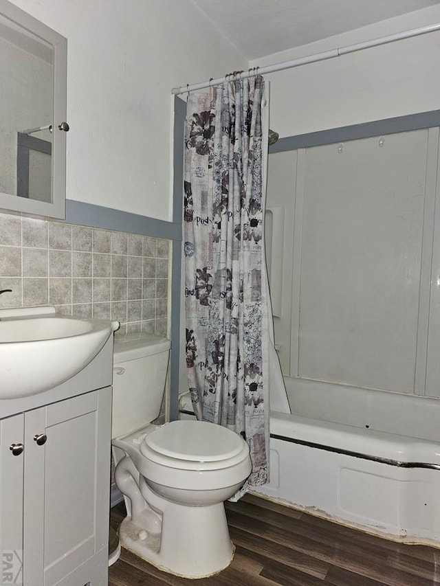 full bathroom with toilet, shower / tub combo with curtain, wood finished floors, vanity, and tile walls