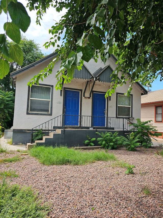 bungalow-style house featuring stucco siding