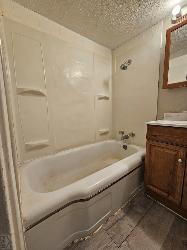 bathroom featuring shower / washtub combination, a textured ceiling, vanity, and wood finished floors