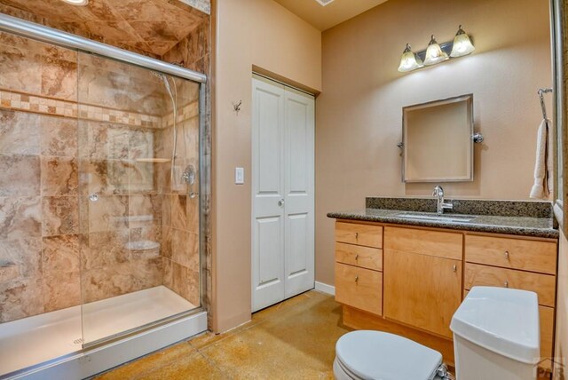 bathroom with a stall shower, vanity, and toilet