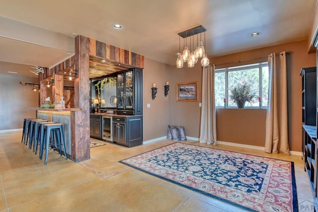 interior space featuring a peninsula, baseboards, a kitchen breakfast bar, and recessed lighting