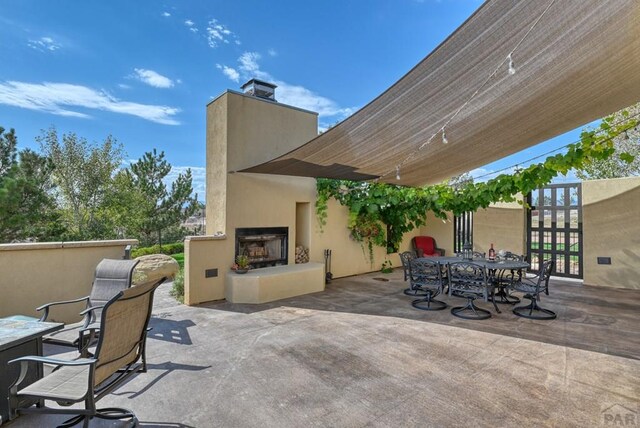 view of patio featuring outdoor dining area and a fireplace