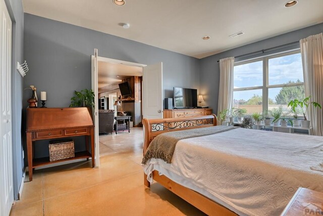 bedroom with concrete floors, visible vents, and recessed lighting