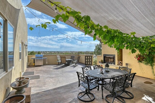 view of patio featuring exterior fireplace and outdoor dining area