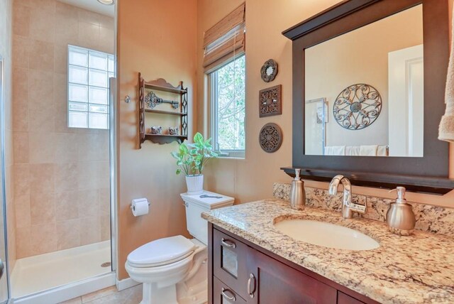 bathroom with toilet, tile patterned floors, a shower stall, and vanity