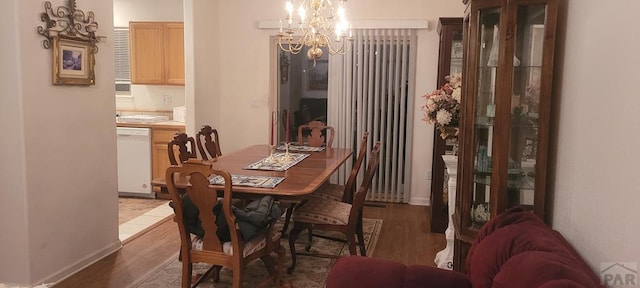 dining area with dark wood-type flooring and a notable chandelier