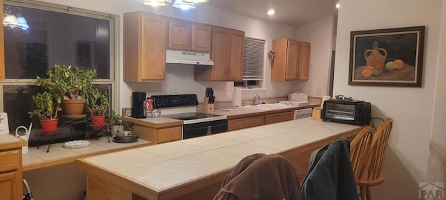 kitchen with tile countertops, black range with electric stovetop, stainless steel dishwasher, under cabinet range hood, and a sink