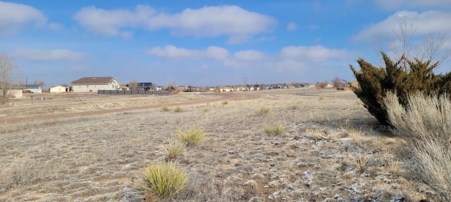 view of yard featuring fence and a rural view