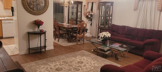 living room featuring baseboards, a chandelier, and wood finished floors